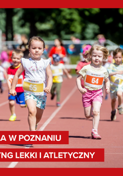 Zdjęcie, dzieci z nurmerami startowymi na koszulkach biegną po stadionie.