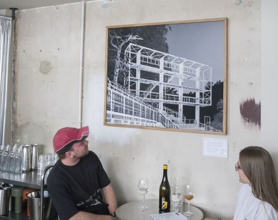 Chłopak i dziewczyna piją wino przy stoliku.