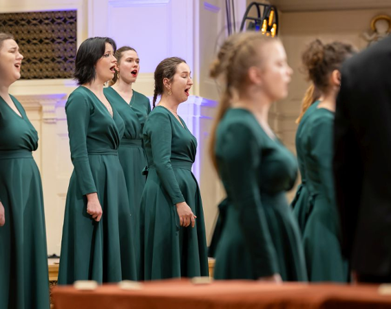 Chórzystki w zielonych sukniach podczas występu.
