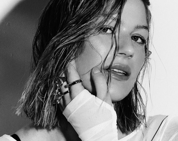 Czarno-biały portret kobiety dotykającej dłonią twarzy.