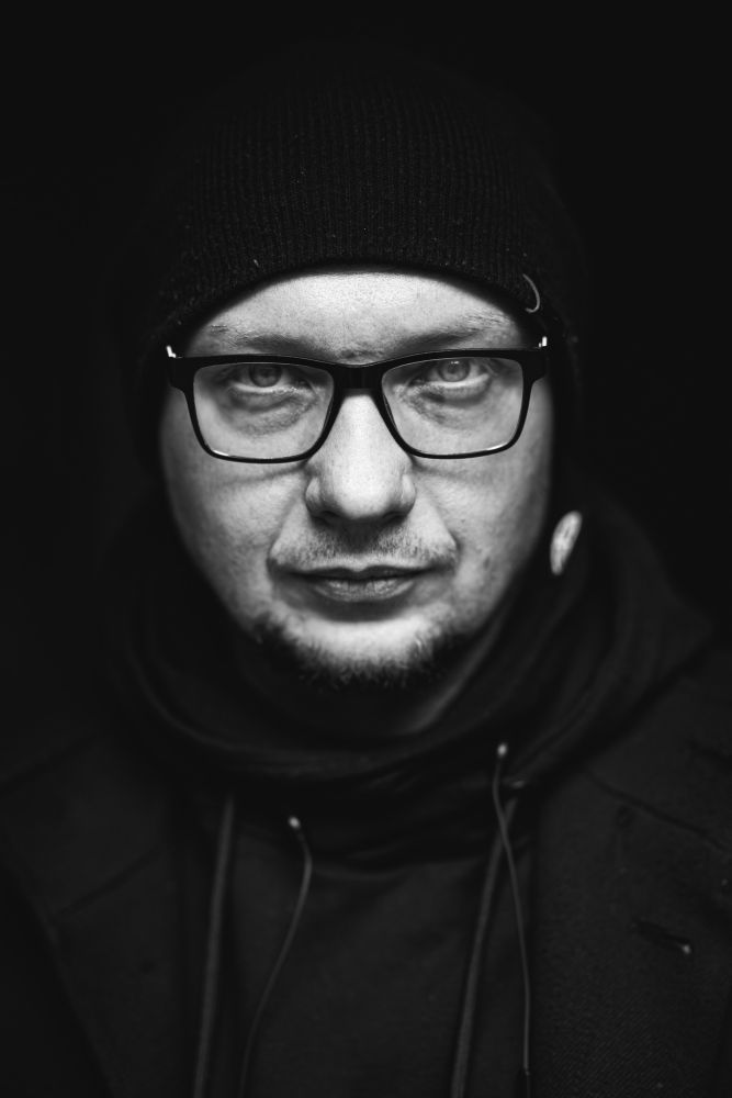 Czarno-biały portret mężczyzny w okularach.