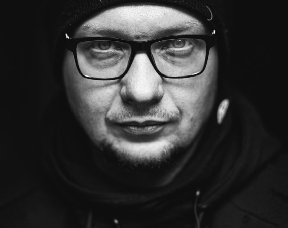 Czarno-biały portret mężczyzny w okularach.