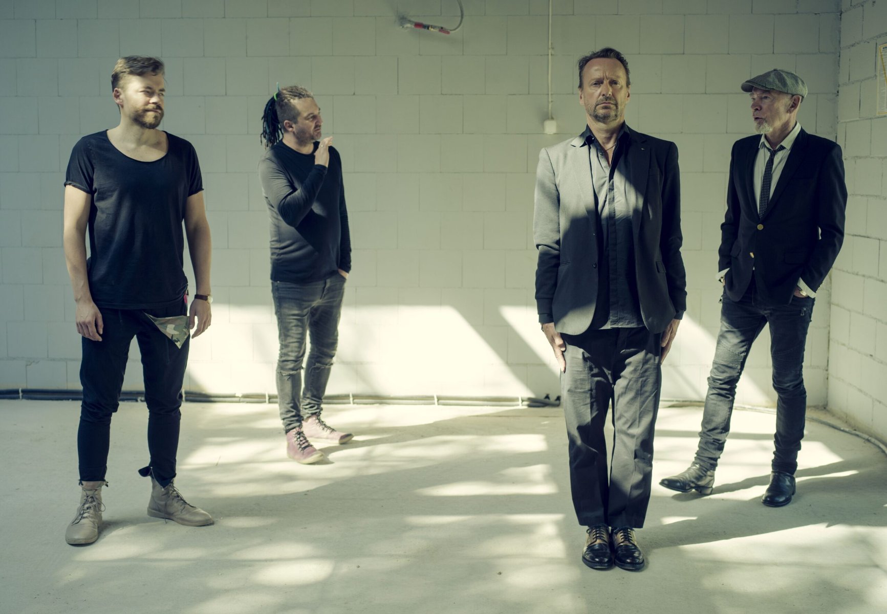 Czterech mężczyzn w łaźni, dwóch młodych, dwóch starszych, eleganckie ubrania