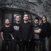 Zdjęcie pięciu mężczyzn w czarnych koszulkach, którzy stoją na tle odrapanej ściany.