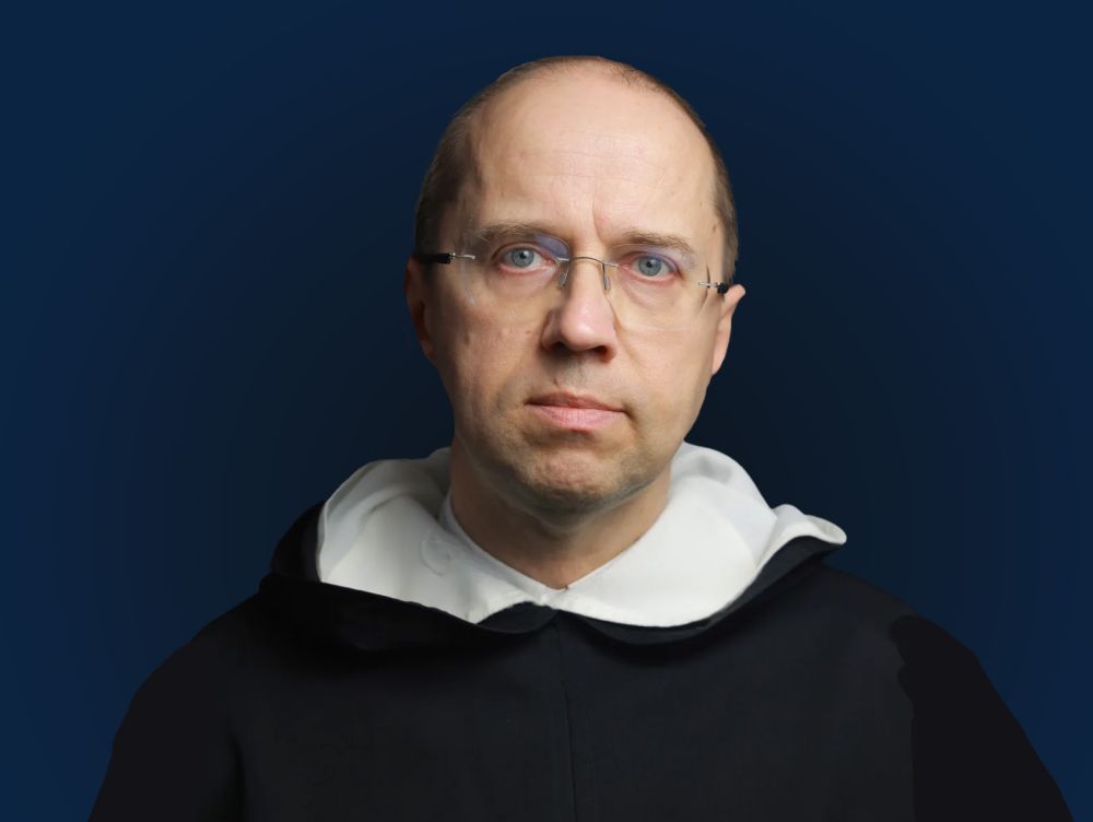 Duchowny w czarnym habicie z białym kołnierzem.