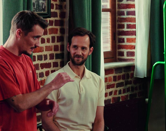 Dwaj mężczyźni rozmawiają w pokoju.