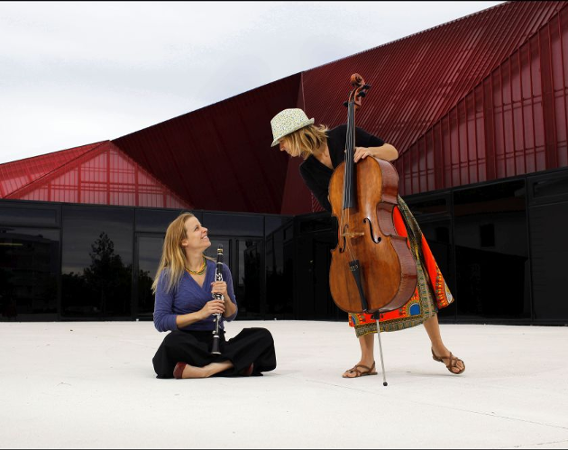 Dwie uśmiechnięte kobiety z instrumentami.