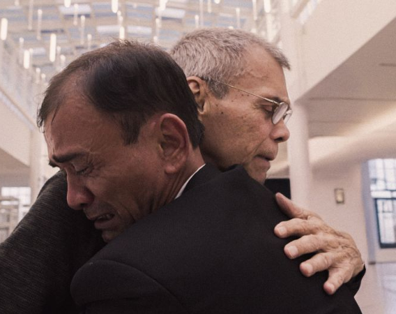 Dwóch mężczyzn przytula się.