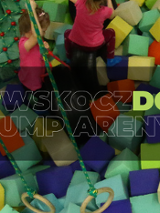 Dzieci w parku trampolin bawiące się wśród miękkich klocków i na linach.