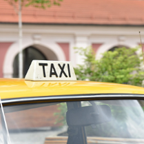 Zdjęcie, dach żółtego samochodu, na nim napis Taxi.