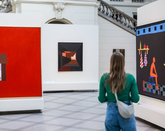 Dziewczyna przygląda się wystawie, stoi tyłem.