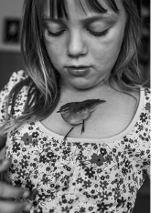 dziewczynka z ptaszkiem na dekolcie