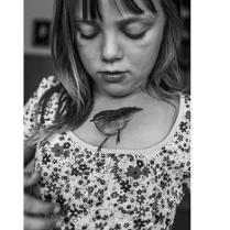 dziewczynka z ptaszkiem na dekolcie