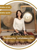 Artystka klęczy wśród mis i gongów w okrągłej złotej ramce, z boku napisy informujące o wydarzeniu.