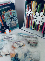 Zdjęcie przedstawia książki i ozdoby świąteczne ułożone na stoliku.