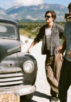 Dwóch mężczyzn stojących przy samochodzie.