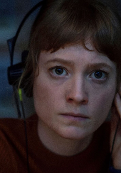 Kadr z filmu, młoda dziewczyna z słuchawkami na uszach wpatruje się przed siebie.