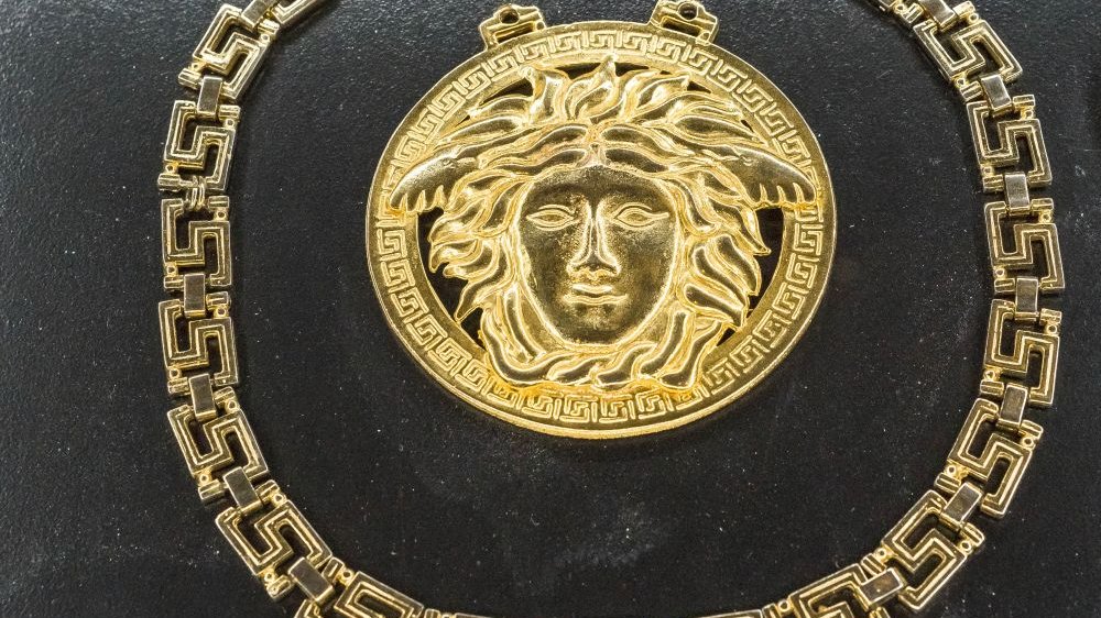 Złota biżuteria z logotypami domu mody Versace.