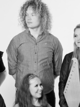 Na czarno-białej fotografii uwiecznionych jest sześcioro członków zespołu Okra ustawionych niejako w dwóch rzędach. W pierwszym siedzą na krzesłach: kobieta i dwaj mężczyźni. Za nimi stoją kolejne dwie panie i jeden pan. Niemal każdy trzyma jakiś instrument - akordeon, tamburyn z membraną i wspomniane w opisie zespołu: cytrę kantele i lirę smyczkową jouhikko. Niektórzy artyści patrzą w obiektyw, inni na siebie nawzajem. Wszyscy są radośnie uśmiechnięci.