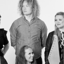 Na czarno-białej fotografii uwiecznionych jest sześcioro członków zespołu Okra ustawionych niejako w dwóch rzędach. W pierwszym siedzą na krzesłach: kobieta i dwaj mężczyźni. Za nimi stoją kolejne dwie panie i jeden pan. Niemal każdy trzyma jakiś instrument - akordeon, tamburyn z membraną i wspomniane w opisie zespołu: cytrę kantele i lirę smyczkową jouhikko. Niektórzy artyści patrzą w obiektyw, inni na siebie nawzajem. Wszyscy są radośnie uśmiechnięci.