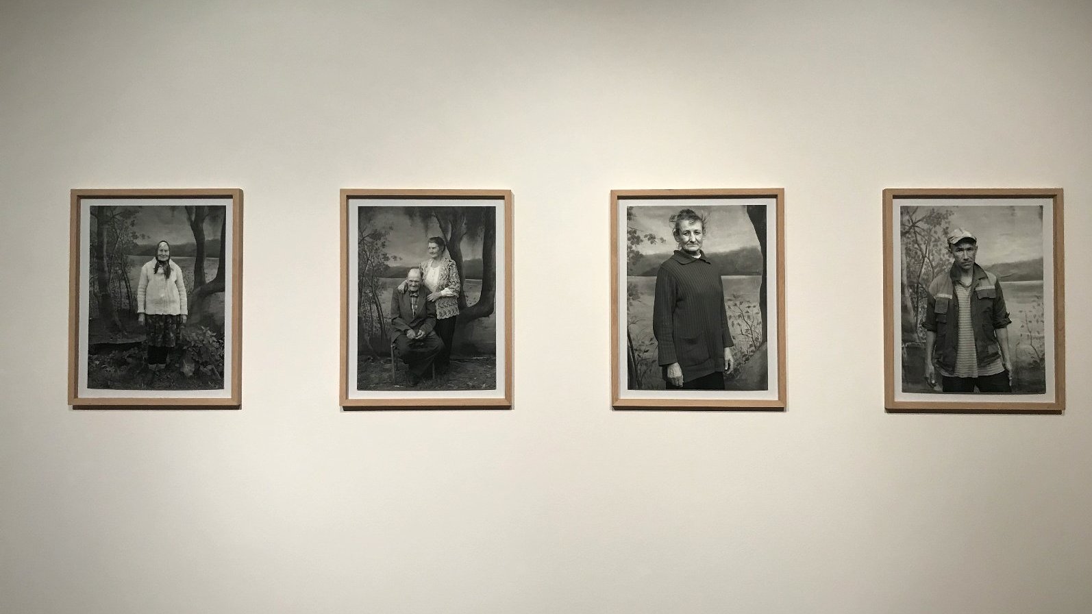 Cztery fotografie portretowe w ramach, które wiszą na ścianach.