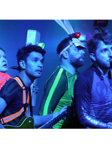 Na zdjęciu czworo młodych osób, stoją jeden za drugim, patrzą w tym samym kierunku, w rękach trzymają różne instrumenty muzyczne.