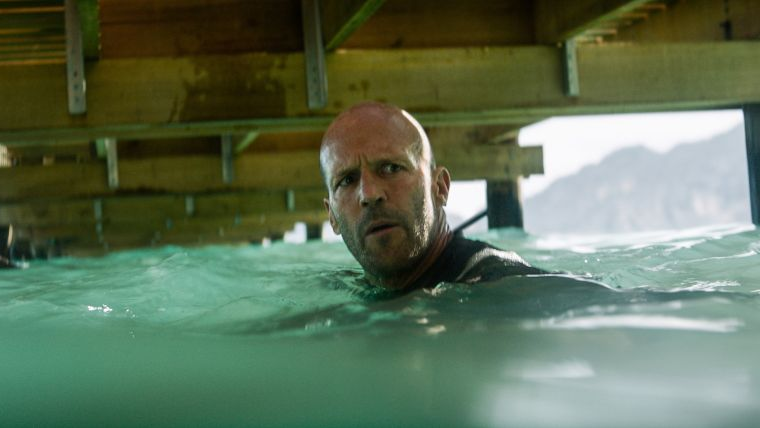 Bohater filmu - łysy mężczyzna w średnim wieku - pływa w wodzie, patrzy na jakiś nieokreślony bliżej punkt.