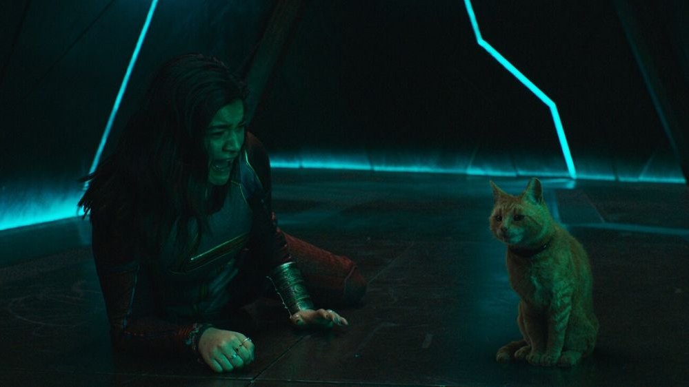 Superbohaterka leży na podłodze, płacze. Obok niej rudy kot. Jest ciemno.