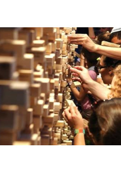 Ludzie wyjmuja z muru klocki.