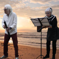 Danuta i Dariusz Stoccy koncertują na plaży. W tle morze.