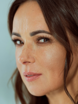 Fotografia przedstawia profil artystki na niebieskim tle.