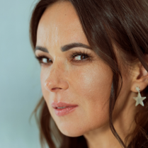 Fotografia przedstawia profil artystki na niebieskim tle.