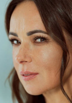 Fotografia przedstawia profil artystki na niebieskim tle.