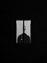 Jedna z prac Piotra Zugaja. Widać zdjęcie człowieka, którego widok jest załamany przez wewnętrzne ramy okienne.