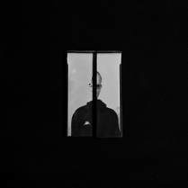 Jedna z prac Piotra Zugaja. Widać zdjęcie człowieka, którego widok jest załamany przez wewnętrzne ramy okienne.