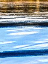 Odbicie zachodzącego słońca na tafli wody jeziora.