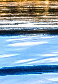 Odbicie zachodzącego słońca na tafli wody jeziora.