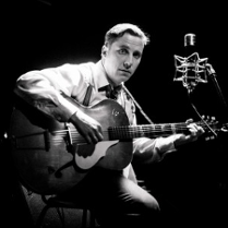 Fotografia wykonana przez Bartka Murackiego przedstawiająca PAwła Sołtysa (pseudonim Pablopavo) grającego na gitarze. Zdjęcie czarno-białe.