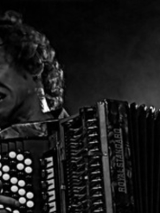 Czarno-biały portret Yegora Zabelova, z pasją grającego na akordeonie. Jego Twarz wykrzywia grymas oddający zaangażowanie, temperament i namiętność artysty.