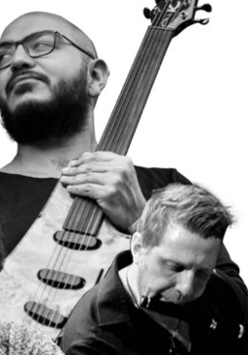 Grafika to kolaż czarno-białych portretów trzech muzyków. Jeden z nich trzyma gitarę, drugi gra na flecie poprzecznym, trzeci - na tabli.