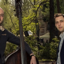 Na pierwszym planie stoi czterech mężczyzn trzymających instrumenty muzyczne, dwóch cymbały (Balázs i Jenő), gitaręoraz kontrabas. Muzycy są elegancko ubrani. Na drugim planie znajdują się gęste drzewa, najprawdopodobniej jest to las.