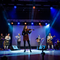 Zdjęcie członków zespołu podczass występu na scenie.