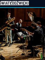 Ciemna fotografia została wykonana na sali koncertowej. Artyści w trakcie koncertu.