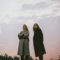 Zdjęcie przedstawia artystki na tle nieba podczas zmierzchu.