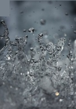 Monochromatyczna fotografia przedstawia w dużym zbliżeniu wzburzoną wodę.