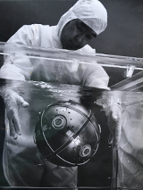 Fotografia naukowca wyciągającego kulę z wody w akwarium.