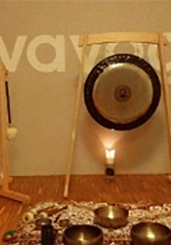 Stojące przy ścianie gongi i palące się przed nimi świece.