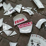 Porozbijana ceramika z napisem "prawa człowieka" na kostce brukowej.
