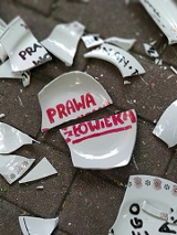 Porozbijana ceramika z napisem "prawa człowieka" na kostce brukowej.