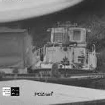 Czarno-białe zdjęcie. Głównym motywem jest motorówka i miejsce do cumowania statków i łodzi. Na zdjęcie zostały nałożone napisy z tytułem wystawy.